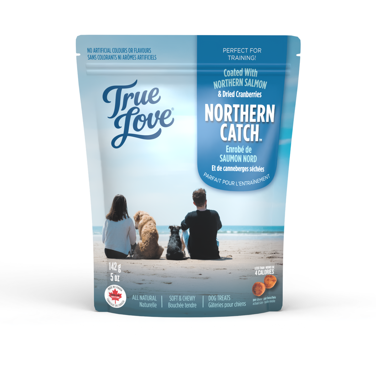 Bag of True Love dog treats with a family and their dogs on an ocean beach. Northern Catch flavour - northern salmon and dried cranberries.